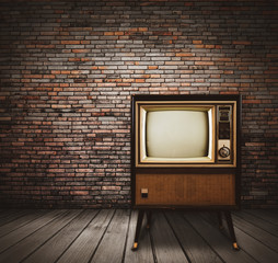 Vintage tv standing in old room with brick wall. Retro object and technology for home decoration.