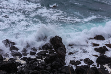 Beautiful Nature scene of sea wave hitting on the black stone shoreline at Jeju Island, South Korea. 