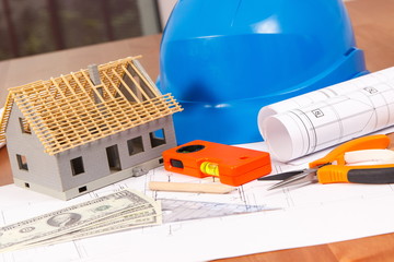 Electrical diagrams, work tools and accessories, house under construction and currencies dollar on desk in office