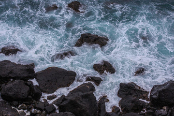 Beautiful Nature scene of sea wave hitting on the black stone shoreline at Jeju Island, South Korea. 