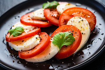 Caprese salad on black stone