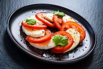 Caprese salad on black stone