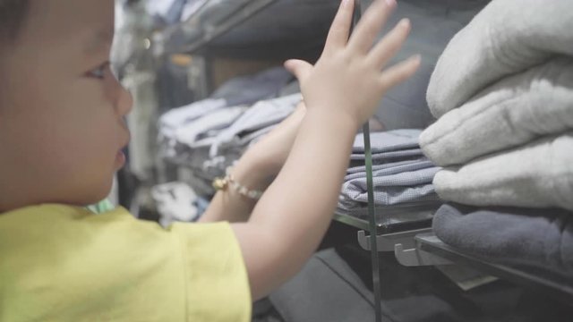 Beautiful mom hold baby boy choose baby cloth in baby fashion shop