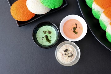 Tiranga Idli or Tricolor Idly cooked in  Indian National Flag colors - saffron or orange, white and green. Served with tiranga chutney. Concept for Indian Independence or Republic day greeting card.
