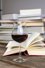book and lwine glass in front of piles of different