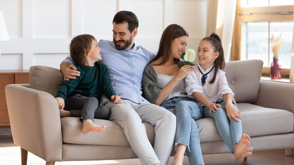 Obraz premium Happy parents enjoy weekend at home with small kids