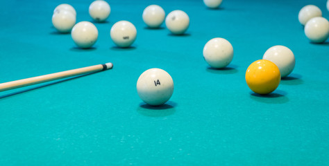 Green billiard table with white balls and cue