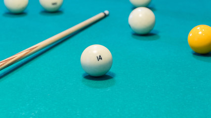 Green billiard table with white balls and cue. Closeup