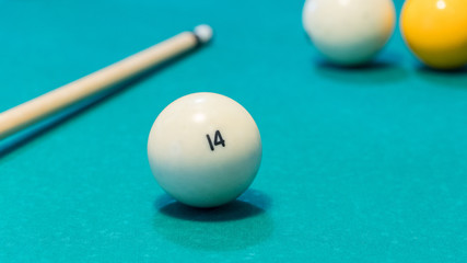 Green billiard table with white balls and cue. Closeup