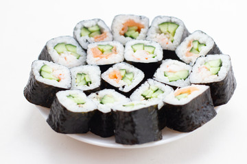 Japanese set of sushi rolls on white plate.