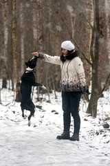 Fototapeta na wymiar girl playing with her dog in the winter forest