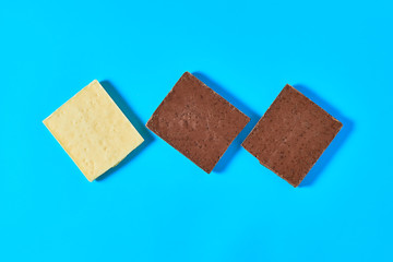 Row of halves various whole porous chocolate bars lies on blue table on kitchen. Top view. Close-up