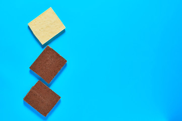 Row of halves various whole porous chocolate bars lies on blue table on kitchen. Space for text....