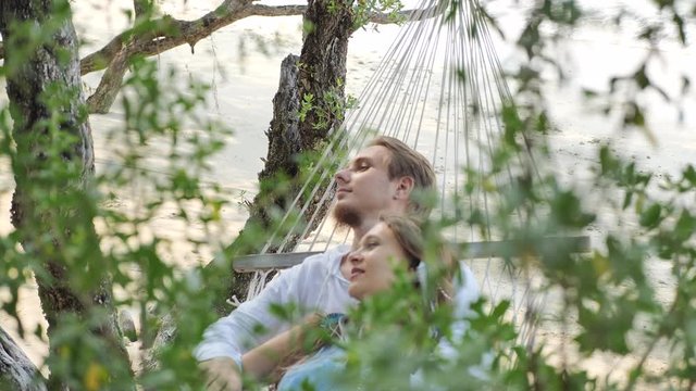 Couple in love spend time in hammock  at sand tropical beach of Thailand island