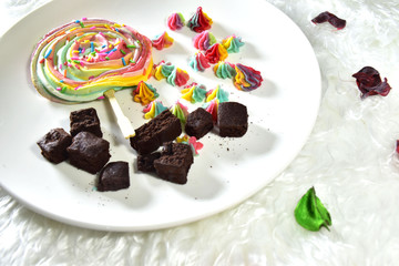 A dessert made from sugar is a rainbow circle. Brownie Candy in white plate