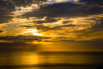 Obraz premium Colorful golden sunset and cloudy sky at the sea.