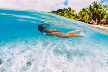 Woman swimming underwater in transparent blue ocean at Mauritius, Le Morne