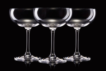 Set of empty luxury champagne glasses in a row isolated on a black background