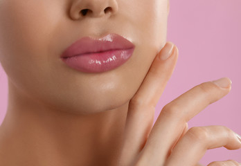 Obraz na płótnie Canvas Young woman with beautiful full lips on pink background, closeup