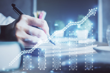 Fototapeta premium Financial forex charts displayed on woman's hand taking notes background. Concept of research. Double exposure