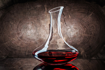 classic decanter with red wine on wooden background