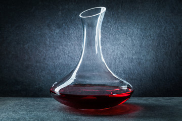 classic glass decanter with red wine on black background