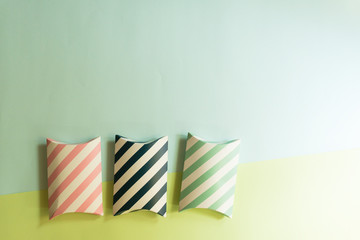 Flat lay Blue, green, pink and white stripes gift boxes  placed on pastel blue and green background with copy space