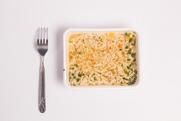 Instant noodles fork on a white background top view