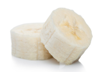 Fresh ripe organic banana sliced pieces on white background with reflection.