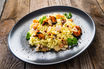 Risotto with seafood on wooden background
