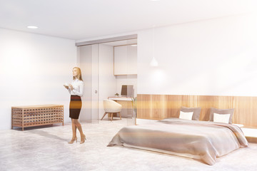 Woman in white bedroom with home office