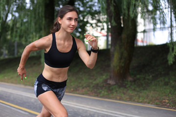 Young woman in sports clothing running while exercising outdoors.