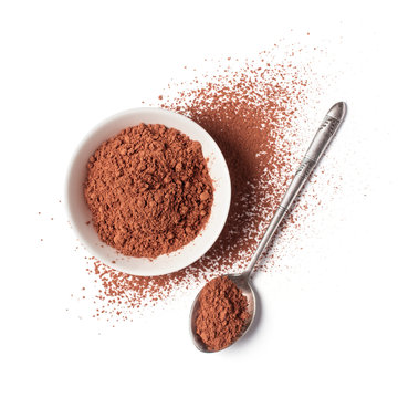 Cocoa powder in white bowl with silver spoon
