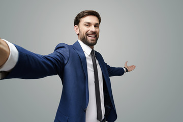 wide angle selfie shot of a young businessman pointing on a copyspace with his hand