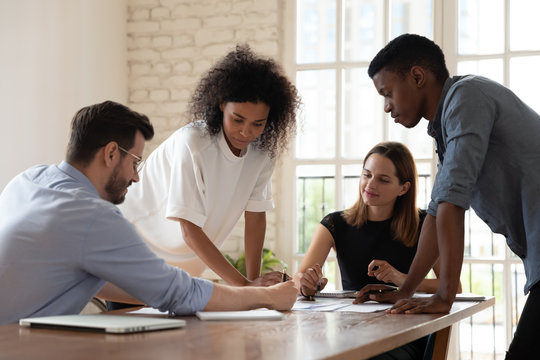 Serious Focused Diverse Employees Team Working With Documents Together