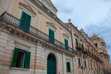 Geschlossene grüne Fensterläden und kleine Balkone an städtischem Haus in Noto, Sizilien