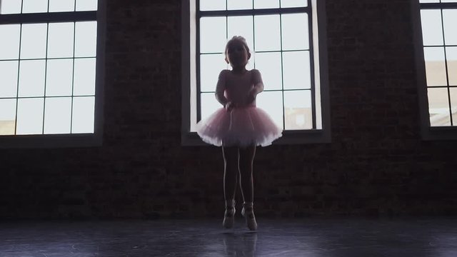 Child Little ballerina in pink tutu dancer. Children's ballet. Slow motion