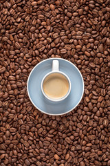 Espresso cup top view and coffee beans as background