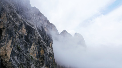 Aerial view of Dolomites Alpine mountains in fog and low clouds. South Tyrol, Italy.