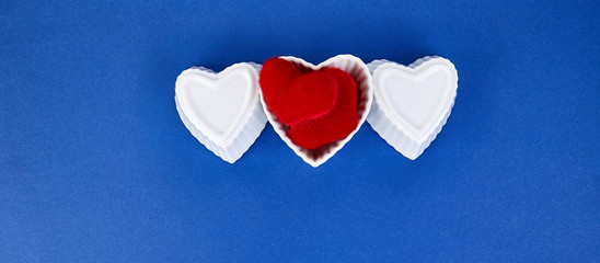 Banner of White ceramic hearts  with red plush  hearts on blue trend color background. Flat lay composition. Romantic, St Valentines Day concept. Love. Copy space.
