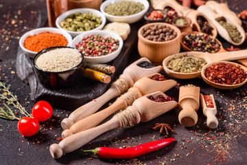 Spices and herbs over black stone background. Top view with free space for menu or recipes