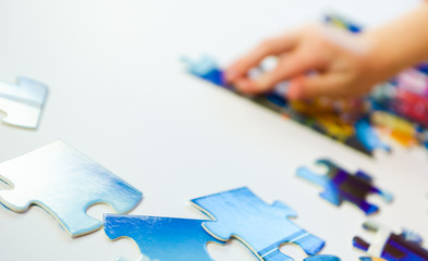 Little hand five year old girl puts together a puzzle for kids close-up - 316506335