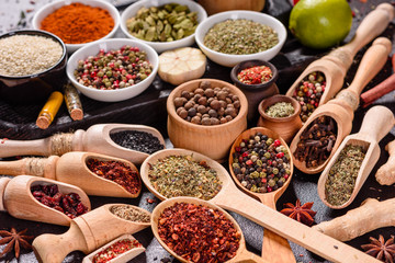 Spices and herbs over black stone background. Top view with free space for menu or recipes