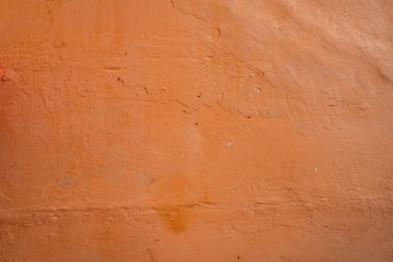 Old rough wall texture for background.  Wallpaper with vintage or retro colors.  Dark orange background.