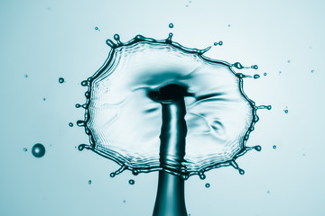 Water splash crown. Drop collision on blue background