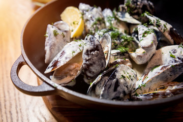 Mussels with garlic white sauce in a bowl. Restaurant