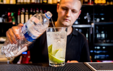 Bartender is making cocktail at bar counter. Fresh cocktails. Barman at work. Restaurant. Nightlife.