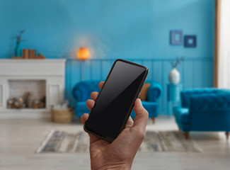 Cellphone screen detail on the man hand and interior background