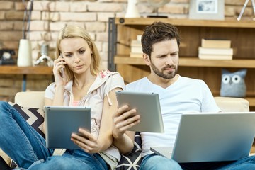 Busy couple lost in modern technology