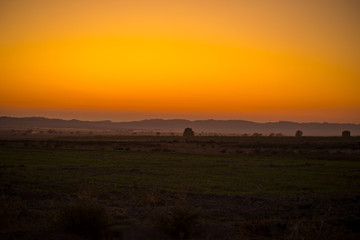 Fototapeta na wymiar Sunset landscape view of silhouette mountains and lonely trees in Azerbaijan. Sheki